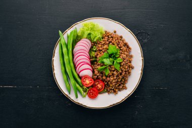 Mercimek turp, domates, fasulye ve sebze ile. Sağlıklı gıda. Siyah ahşap bir masa üzerinde. Üstten görünüm. Metin için boş alan.