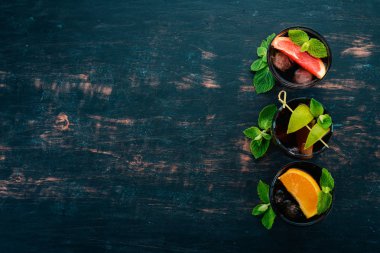 Narenciye meyve ve nane ile kokteyller. Limon, greyfurt, limon, portakal. Ahşap bir arka plan üzerinde. Üstten görünüm.