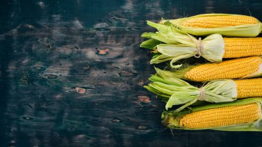 Siyah ahşap bir masa üzerinde taze sarı Mısır. Sebze. Üstten görünüm. Kopya alanı.