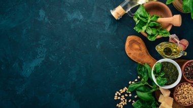 Geleneksel fesleğen pesto sos. Fesleğen, parmesan peyniri, zeytin yağı, çam fıstığı, biber, sarımsak. Üstten görünüm. Taş masanın üstünde. Metin için boş alan.