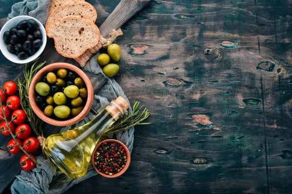 Oliven Olivenöl Brot Käse Und Gewürze Auf Schwarzem Holzgrund Freiraum — Stockfoto