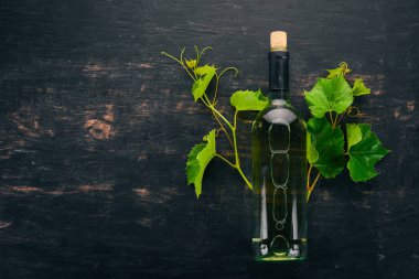 Bir şişe beyaz şarap. Şarap. Üstten görünüm. Siyah bir arka plan üzerinde. Metin için boş alan.