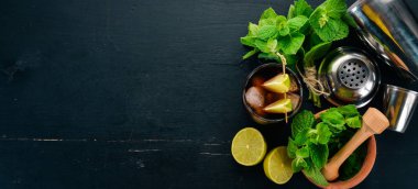 Cuba libre kokteyl cam. Limon, nane. Siyah ahşap arka plan üzerinde. Metin için boş alan.