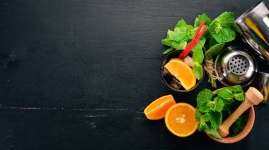 Portakal ve nane ile alkollü kokteyl. Negroni, Long Island, rom-kola. Siyah ahşap arka plan üzerinde. Metin için boş alan.