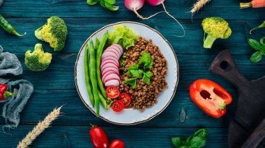 Mercimek turp, domates, fasulye ve sebze ile. Sağlıklı gıda. Mavi ahşap bir masa üzerinde. Üstten görünüm. Metin için boş alan.