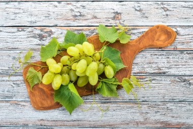 Üzüm. Beyaz ahşap zemin üzerinde taze beyaz üzüm. Üstten görünüm. Metin için boş alan.