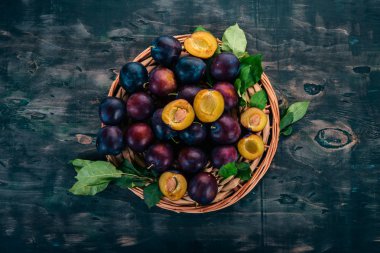 Taze erik yaprakları ile. Meyve. Siyah ahşap arka plan üzerinde. Üstten görünüm. Metniniz için boş alan.