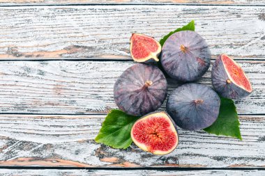 İncir. Beyaz ahşap bir masa üzerinde incir, taze meyve. Metin için özgür yer. Üstten görünüm.