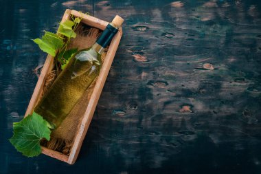 Bir şişe beyaz şarap. Şarap. Üstten görünüm. Siyah bir arka plan üzerinde. Metin için boş alan.