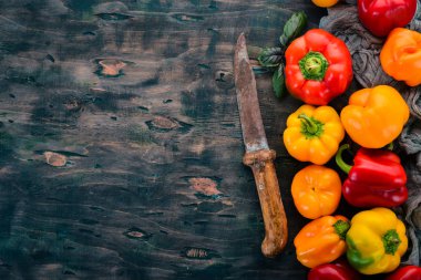 Taze renkli kırmızı biber. Üstten görünüm. Siyah ahşap arka plan üzerinde. Metin için boş alan.