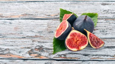 İncir. Beyaz ahşap bir masa üzerinde incir, taze meyve. Metin için özgür yer. Üstten görünüm.