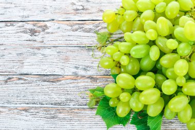 Üzüm. Beyaz ahşap zemin üzerinde taze beyaz üzüm. Üstten görünüm. Metin için boş alan.