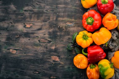 Taze renkli kırmızı biber. Üstten görünüm. Siyah ahşap arka plan üzerinde. Metin için boş alan.