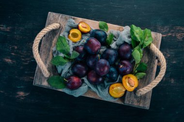 Taze erik yaprakları ile. Meyve. Siyah ahşap arka plan üzerinde. Üstten görünüm. Metniniz için boş alan.