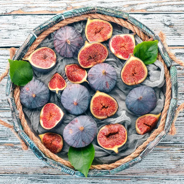 Beyaz ahşap zemin üzerinde bir ahşap kutu incir. Metin için özgür yer. Üstten görünüm.