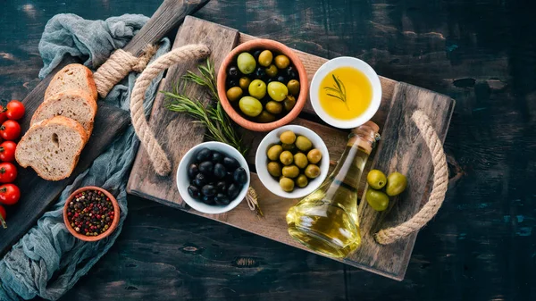 Set Olives Olive Oil Bread Cheese Spices Black Wooden Background — Stock Photo, Image