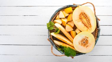 Kavun mezarda. Kavun parçalara dilimlenmiş. Ahşap bir arka plan üzerinde. Metin için özgür yer. Üstten görünüm.