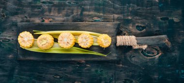 Siyah ahşap bir masa üzerinde taze sarı Mısır. Sebze. Üstten görünüm. Kopya alanı.