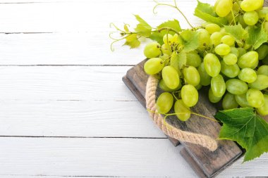 Üzüm. Beyaz ahşap zemin üzerinde taze beyaz üzüm. Üstten görünüm. Metin için boş alan.