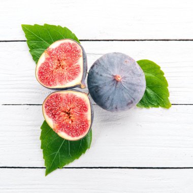 İncir. Beyaz ahşap bir masa üzerinde incir, taze meyve. Metin için özgür yer. Üstten görünüm.