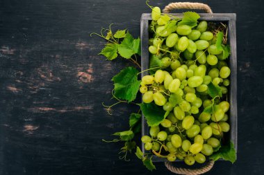 Üzüm mezarda. Üzüm yaprakları. Üstten görünüm. Siyah bir arka plan üzerinde. Metin için boş alan.