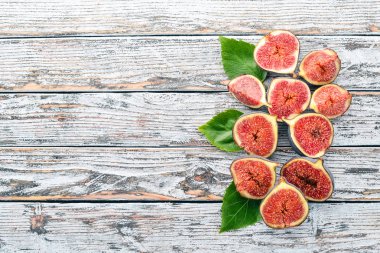 İncir. Beyaz ahşap bir masa üzerinde incir, taze meyve. Metin için özgür yer. Üstten görünüm.