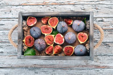 Beyaz ahşap zemin üzerinde bir ahşap kutu incir. Metin için özgür yer. Üstten görünüm.