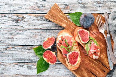 İncir, jambon ve peynirli sandviç. Eski arka plan üzerinde. Sağlıklı gıda. Metin için özgür yer. Üstten görünüm.