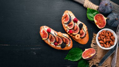 İncir, yaban meyveleri ve peynirli sandviç. Eski arka plan üzerinde. Tatlı. Metin için özgür yer. Üstten görünüm.