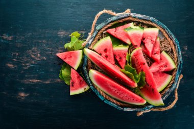 Karpuz mezarda. Karpuz parçalara dilimlenmiş. Ahşap bir arka plan üzerinde. Metin için özgür yer. Üstten görünüm.