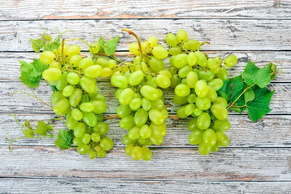 Grape. Fresh white grapes on a white wooden background. Top view. Free space for text.