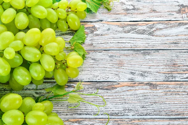 Grape. Fresh white grapes on a white wooden background. Top view. Free space for text.