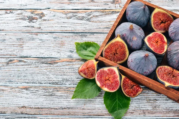 Beyaz ahşap zemin üzerinde bir ahşap kutu incir. Metin için özgür yer. Üstten görünüm.