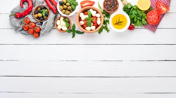Mozzarella Kirschtomaten Basilikumblätter Oliven Pfeffer Salatcaprese Auf Einem Weißen Holztisch — Stockfoto