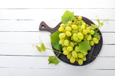 Üzüm. Beyaz ahşap zemin üzerinde taze beyaz üzüm. Üstten görünüm. Metin için boş alan.