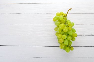Üzüm. Beyaz ahşap zemin üzerinde taze beyaz üzüm. Üstten görünüm. Metin için boş alan.