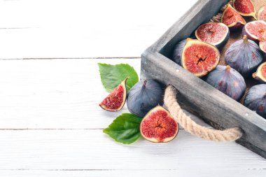 Beyaz ahşap zemin üzerinde bir ahşap kutu incir. Metin için özgür yer. Üstten görünüm.