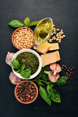 Fesleğen pesto sosu hazırlarken. Fesleğen, parmesan peyniri, zeytinyağı. Üstten görünüm. Siyah ahşap arka plan üzerinde. Metin için boş alan.