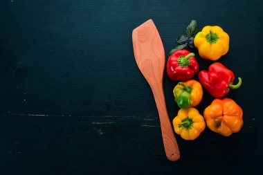 Taze renkli kırmızı biber. Üstten görünüm. Siyah ahşap arka plan üzerinde. Metin için boş alan.