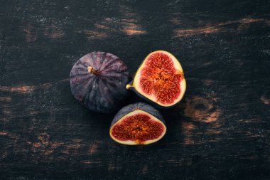 Taze incir yaprakları üzerinde siyah ahşap bir masa ile. Metin için özgür yer. Üstten görünüm.