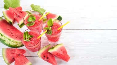 Karpuz suyu nane ve bir bardak buz ile. Kavun. Beyaz ahşap zemin üzerinde. Metin için özgür yer. Üstten görünüm.