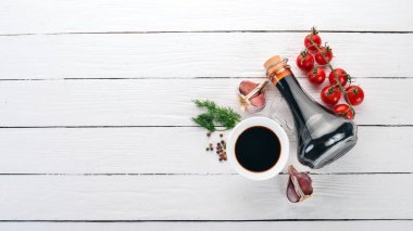 Soya sosu bir cam kavanoza. Üstten görünüm. Beyaz ahşap zemin üzerinde. Metin için boş alan.