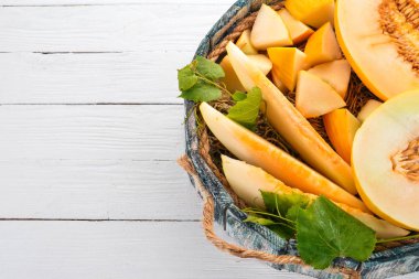 Kavun mezarda. Kavun parçalara dilimlenmiş. Ahşap bir arka plan üzerinde. Metin için özgür yer. Üstten görünüm.