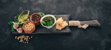 Geleneksel fesleğen pesto sos. Fesleğen, parmesan peyniri, zeytin yağı, çam fıstığı, biber, sarımsak. Üstten görünüm. Taş masanın üstünde. Metin için boş alan.