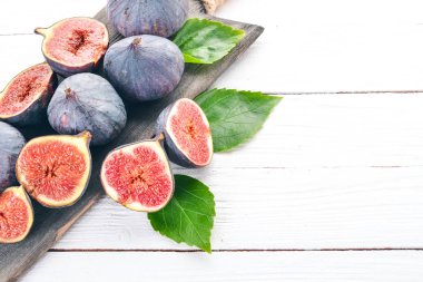 İncir. Beyaz ahşap bir masa üzerinde incir, taze meyve. Metin için özgür yer. Üstten görünüm.