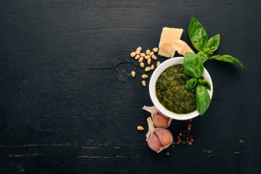 Fesleğen pesto sosu hazırlarken. Fesleğen, parmesan peyniri, zeytinyağı. Üstten görünüm. Siyah ahşap arka plan üzerinde. Metin için boş alan.