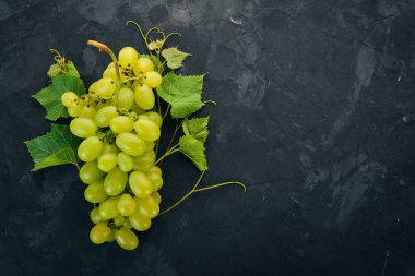 Yeşil üzüm üzüm yaprakları taş bir tablo ile. Üstten görünüm. Metin için boş alan.