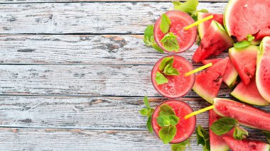 Karpuz suyu nane ve bir bardak buz ile. Kavun. Beyaz ahşap zemin üzerinde. Metin için özgür yer. Üstten görünüm.