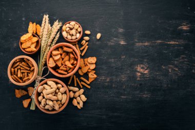 Aperatif bira için. Tuzlu kraker, cips, fındık, fıstık, fıstık. Ahşap bir arka plan üzerinde. Metin için özgür yer. Üstten görünüm.