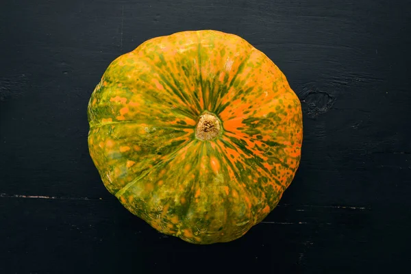 Pumpkin. Fresh vegetables. On a black background. Free space for text. Top view.